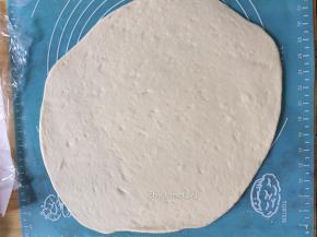 用擀面杖将面团擀开成长方形状
