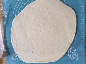 用擀面杖将面团擀开成长方形状
