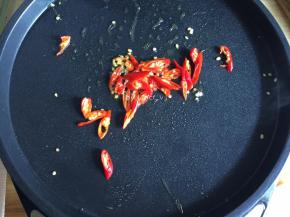 接着将电饼铛180放平，倒入适量油，放入辣椒炒香