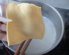 把冲好的牛奶倒入奶锅中，加入奶酪片小火把奶酪片煮融化，中间要不断搅拌，让奶酪片尽快融化