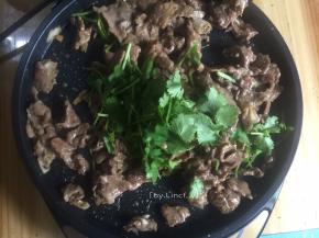 接着将电饼档放平，放适量油，加入腌好的肉炒熟，然后放入香菜即可