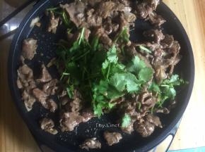 接着将电饼档放平，放适量油，加入腌好的肉炒熟，然后放入香菜即可