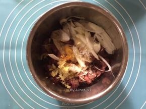 切好的牛肉片放入碗中，加入切片的葱白、老抽、生抽、白胡椒粉、白糖、香油、玉淀粉、料酒、姜末等调味料
