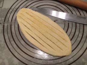 擀成牛舌状，用小刀在上面切几条切口，两头不要切断（注意要直接切至底，不要相连）