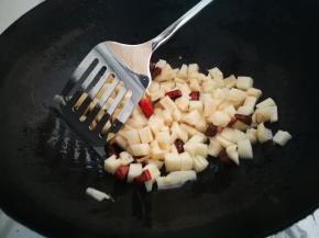 炒到辣椒有些许辣味飘出，注意不要炒糊了，小火炒，放入藕丁，这时火力转大，开始翻炒