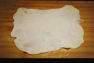 擀好的面皮，中间涂抹一层油，放上同样的一层叠加，再次擀薄