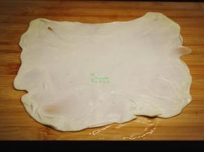 擀好的面皮，中间涂抹一层油，放上同样的一层叠加，再次擀薄