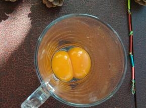 两个蛋黄分离出蛋清，放入无水无油的打蛋盘中；