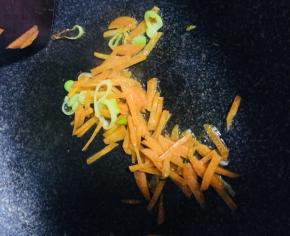 锅内倒油，油热倒入葱姜蒜炒香，倒入胡萝卜丝炒软