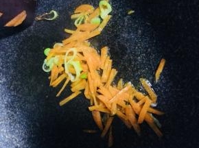 锅内倒油，油热倒入葱姜蒜炒香，倒入胡萝卜丝炒软