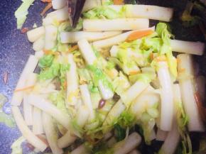 包菜变熟后倒入年糕、黄豆酱、鸡精翻炒均匀即可