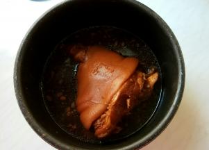 做好开盖，将猪肘翻面，舀汤汁淋几次在肉皮上。再把猪肘放回在锅中，再启动煮个20分钟，煮好后切断电源，焖一夜。