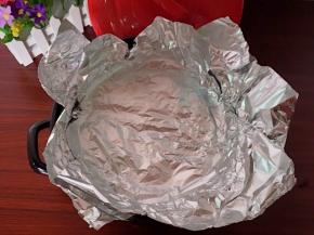 把剩下的锡纸折好放在烤架上面，贴合锅体并把高出锅的锡纸往外翻压