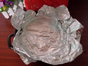把剩下的锡纸折好放在烤架上面，贴合锅体并把高出锅的锡纸往外翻压