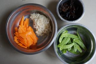 准备好食材，木耳提前浸泡，莲藕、胡萝卜切薄片，荷兰豆去蒂。这些食材都用热水焯一下，并控干水份备用