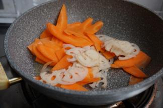 锅里放油，热锅，倒入胡萝卜和莲藕片