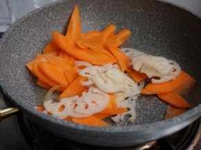 锅里放油，热锅，倒入胡萝卜和莲藕片