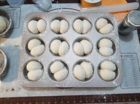 取出烤盘，烤箱上下火200度预热，在面包坯上筛一层高筋面粉。