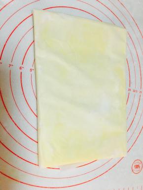 利用油纸，四边的折叠，将黄油擀成你需要的大小。