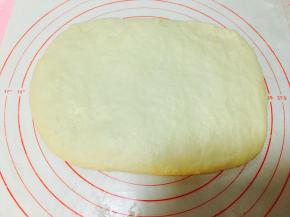 将松弛好的面团，揉光滑。用手边推边按。将面团按扁。