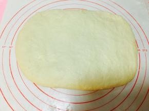 将松弛好的面团，揉光滑。用手边推边按。将面团按扁。