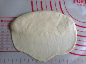 将松驰后的面团擀成15CM长的椭圆形，其中一条长边擀薄