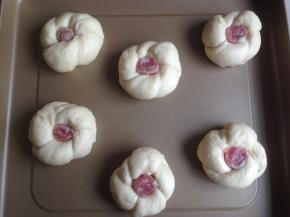 面团打个结，将尾部塞进去，然后在中间放入香肠段