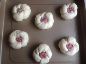 面团打个结，将尾部塞进去，然后在中间放入香肠段