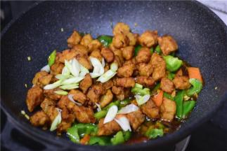 加入酱汁，炒至冒泡，加入肉段，葱花，炒匀即可