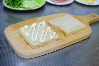 土司切掉边缘，挤上沙拉酱。