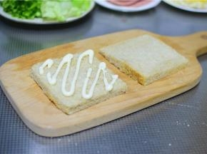 土司切掉边缘，挤上沙拉酱。