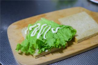 放上一片生菜，挤上沙拉酱。