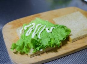 放上一片生菜，挤上沙拉酱。