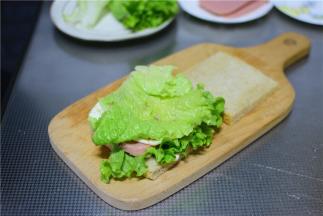 再放一片生菜，挤上沙拉酱。
