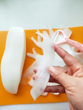 用奈瓷刀削皮刀将萝卜削成薄片