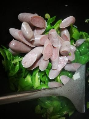 青椒炒至变色，倒入肠