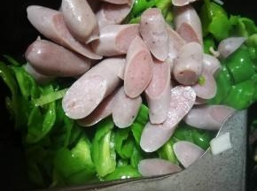 青椒炒至变色，倒入肠