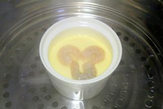 中火蒸5分钟，将腌制好的吓人放在鸡蛋羹上，继续小火蒸5分钟