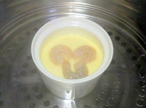 中火蒸5分钟，将腌制好的吓人放在鸡蛋羹上，继续小火蒸5分钟