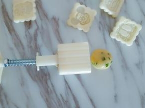 取一个面团揉圆，放入月饼模具中