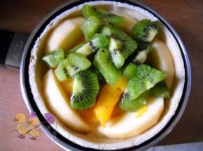 水果去皮，切小块。 水果一层层在饼皮上铺好。