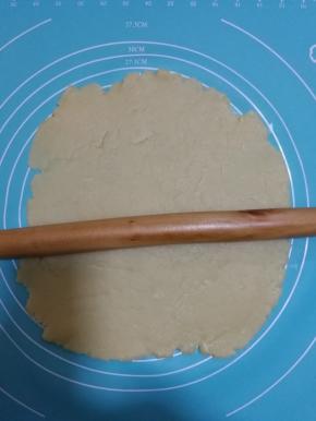 用擀面杖擀开面团。