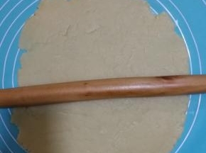 用擀面杖擀开面团。