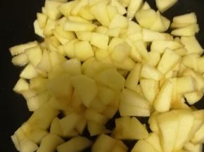 苹果切丁，倒入油锅内，加入糖，翻炒。