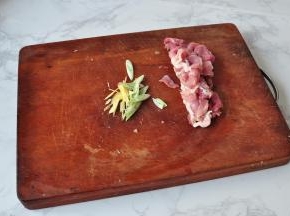 将猪肉切成小段，葱姜也切成细段。