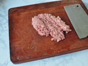将肉与葱姜在一起剁成肉馅。