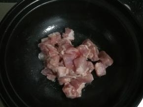 热锅放油，倒入前腿肉翻炒，变色。