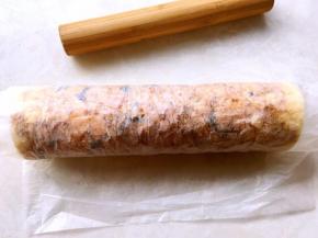 利用擀面杖向外卷起油纸，将蛋糕卷卷起来，卷好之后包裹油纸固定一下形状