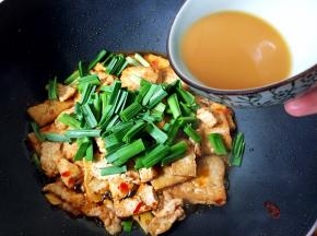 放入蒜苗叶，在菜周围淋上调味汁炒匀，片刻即可出锅。