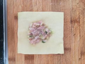 千张中间放上肉馅。然后以肉馅为中点，两边对折过去。